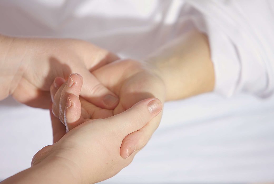 A hand being massaged by a chiropractor.
