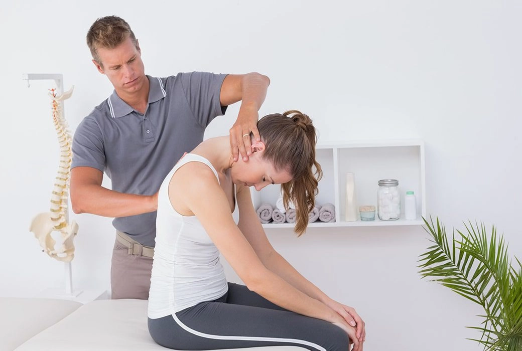 A woman getting her neck treated by a chiropractor.