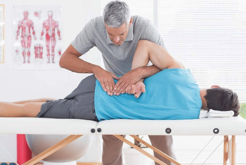 A chiropractor attending to a patient's lower back.