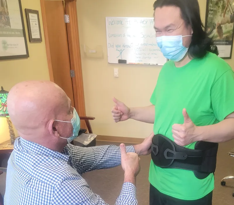 Fitting a patient with low back pain with a brace for his back pain and sciatica.