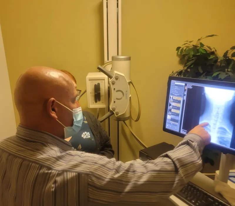 Doctor Brent Wells reviewing x-rays with a patient with neck pain.
