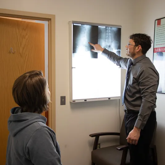Reviewing findings and lower back x-rays with a patient.
