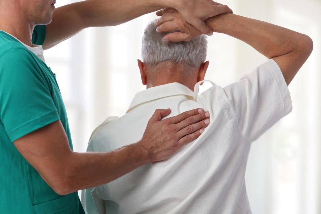 senior with back pain getting adjusted-min