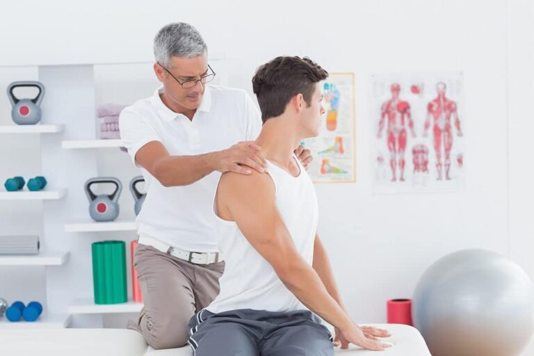 A young man having an examination on his back by a chiropractor.