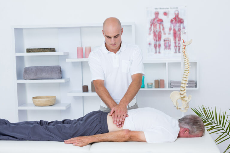 A chiropractor attending to a patient's lower back.