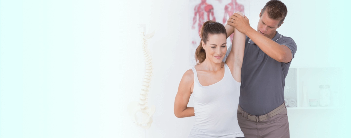 A woman being treated by a chiropractor on her shoulder.