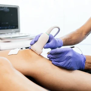 A patient having ultrasound on their knee while being injected.