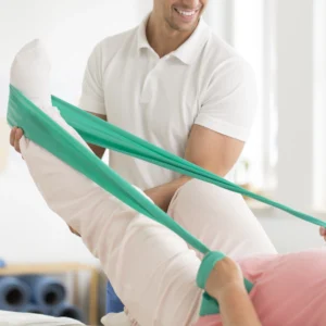 A chiropractor facilitating foot exercises with rubber bands for a patient.