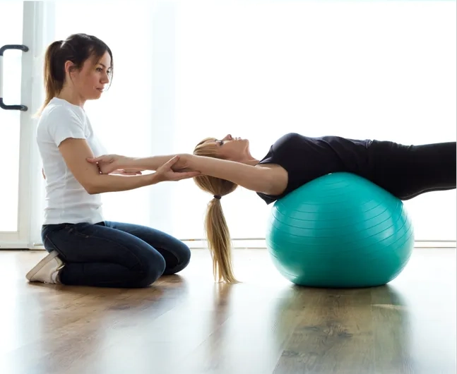 A physical therapist facilitating exercises to a patient.