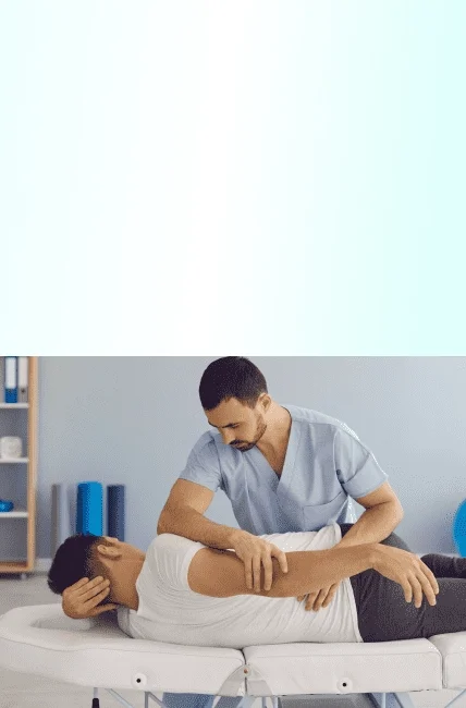 A chiropractor attending to a man's shoulder.