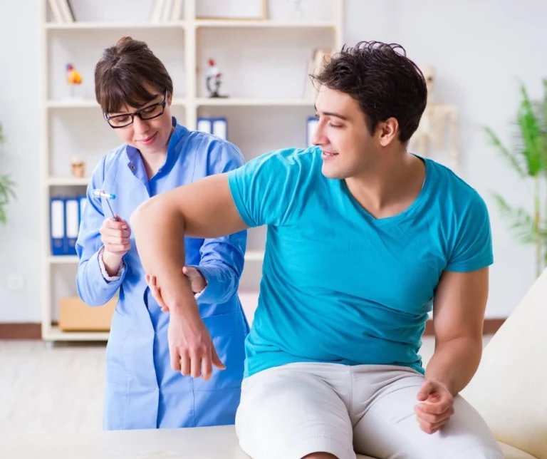 A patient having reflex tests on their elbow by a chiropractor.