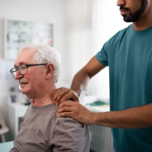 An elderly man being attended by a chiropractor on his neck.