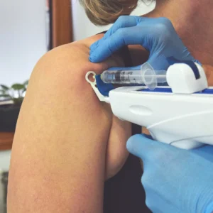 A woman getting an injection in her shoulder.