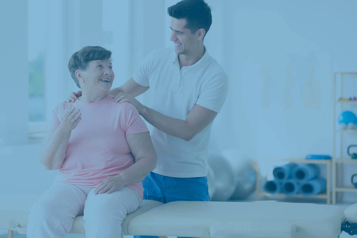 A young chiropractor talking care of a happy elderly woman.
