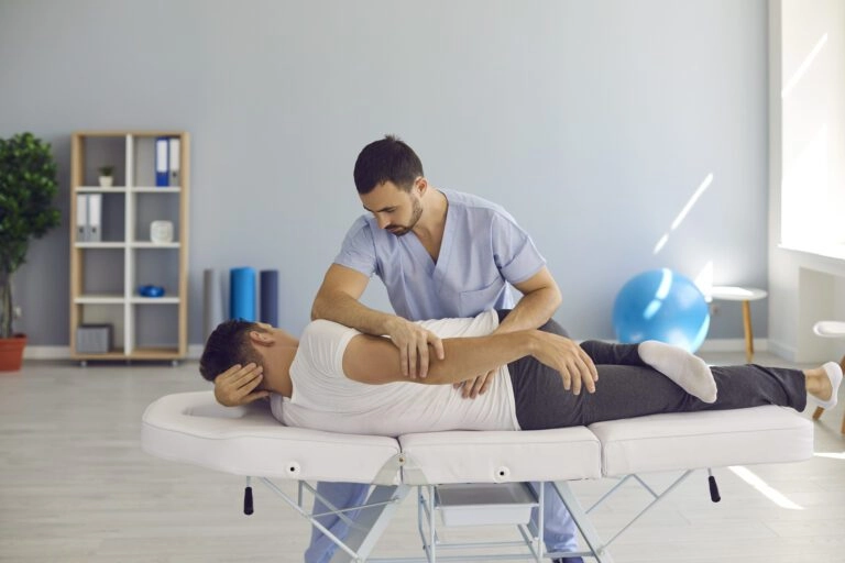 A chiropractor attending to a male patient.