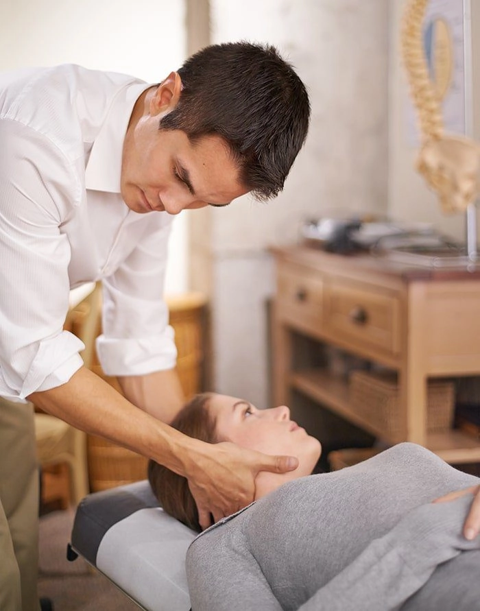 A man giving chiropractic attention to a woman's neck.