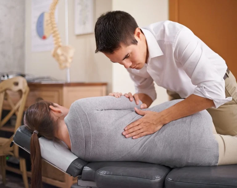 A woman having back adjustments by a chiropractor.