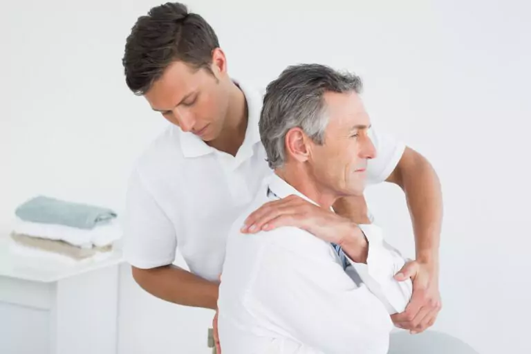 A man being attended by a chiropractor.