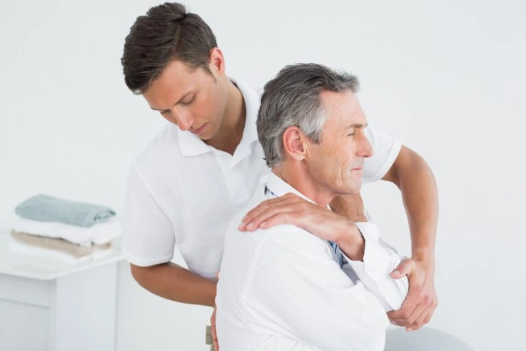 A man having his back checked by a chiropractor.