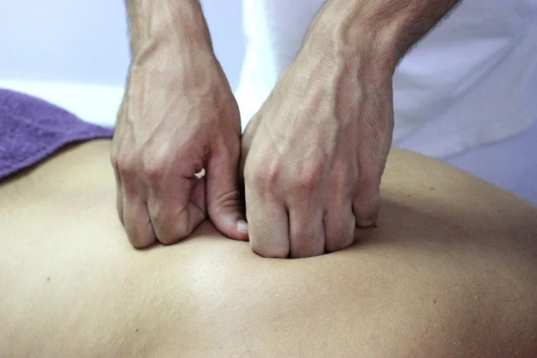 Hands massaging a back.