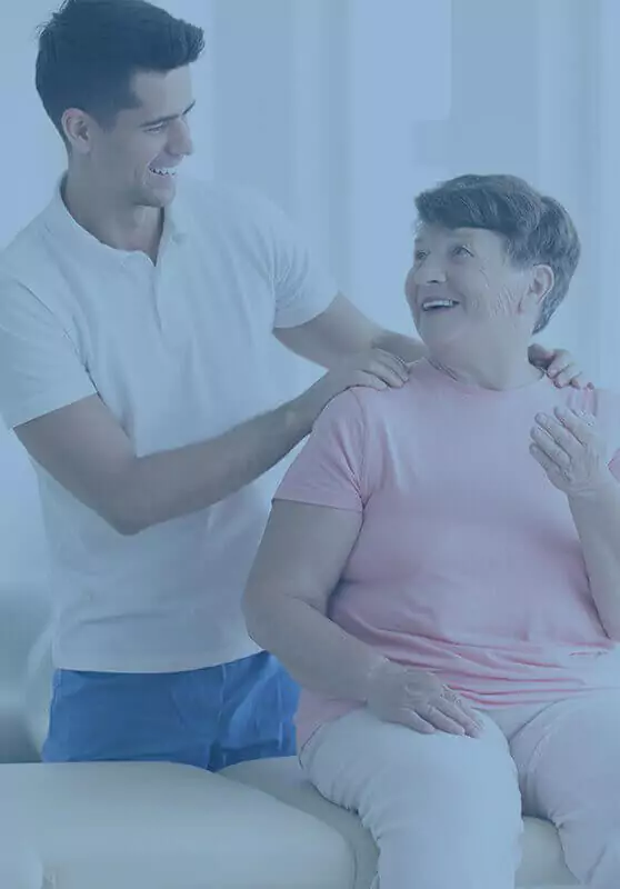 A young chiropractor talking care of a happy elderly woman.