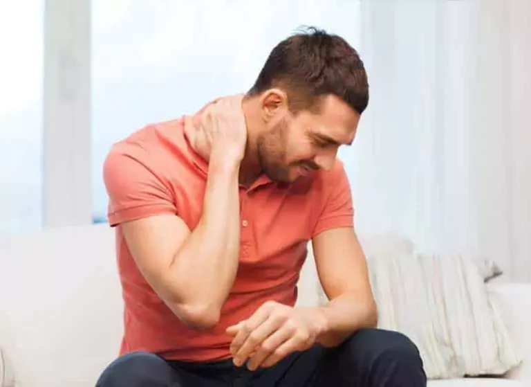 A man touching his neck in pain.