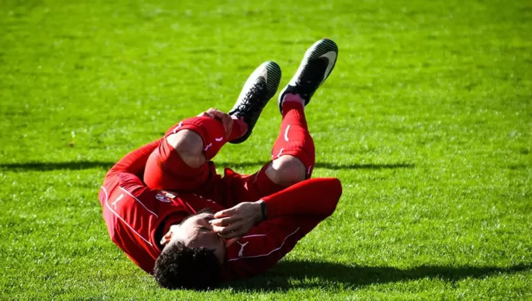 An athlete lying on the pitch injured.
