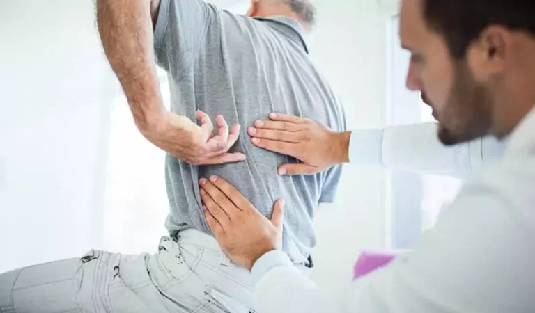 A man having his lower back checked by a chiropractor.
