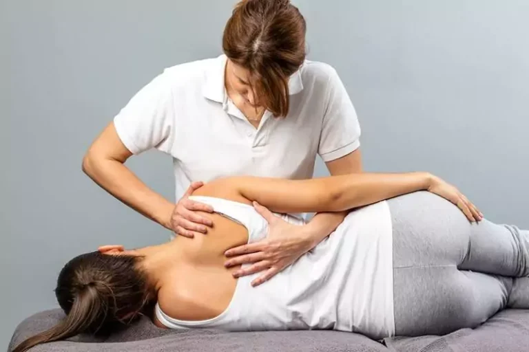 A woman getting a massage while lying on her side.