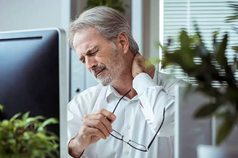 A man feeling pain in his neck.