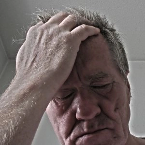 A man touching his head looking desperate.