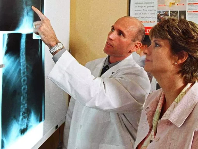 Dr. Brent Wells explaining x-ray images to a woman.