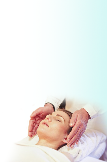 A patient lying on their back and a chiropractor having their hands on each side of the patient's head.